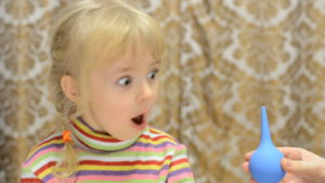 Ребёнок балуется с клизмой
